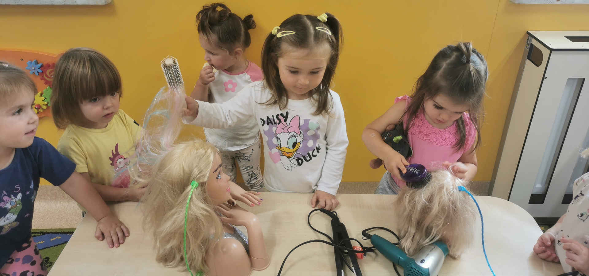 Dzieci podczas fryzjerskiej zabawy z manekinami