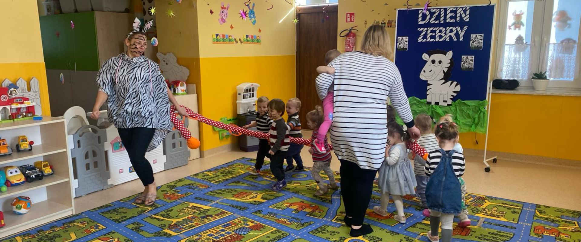 Dzieci z opiekunkami przebrane w stroje zebry