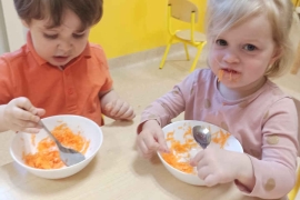 Dzieci jedzą startą marchewkę