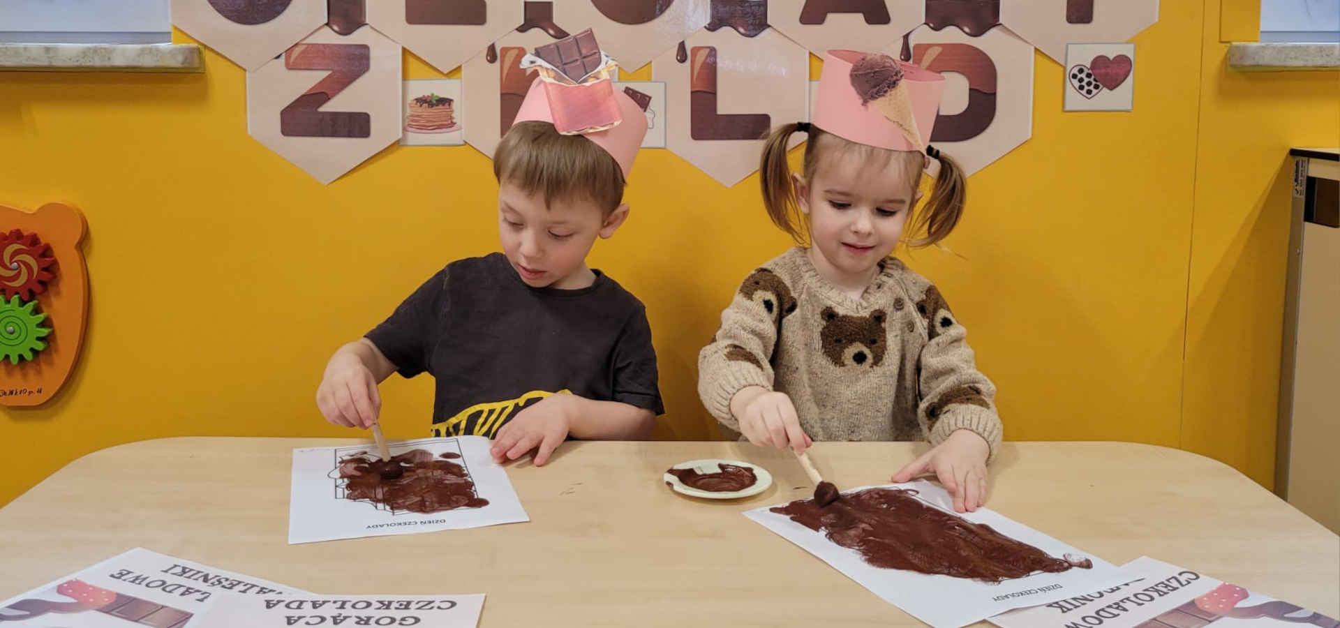 Chłopiec z dziewczynką malują kartki czekoladą